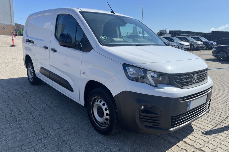 Hvid Peugeot varevogn på asfalteret plads.